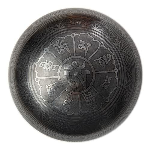 Engraved metal bowl with intricate patterns and symbols.